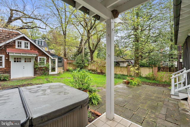 view of patio featuring fence and a hot tub