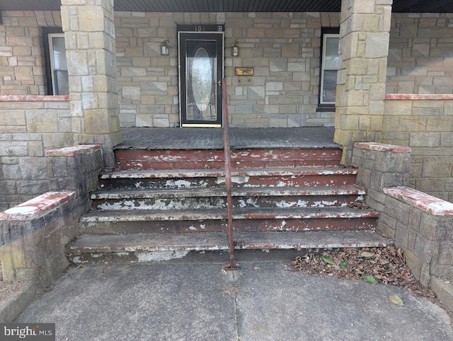 property entrance with stone siding and covered porch