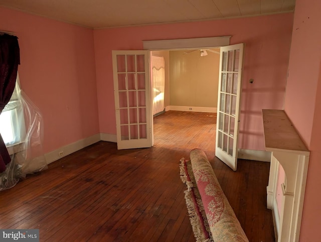 spare room with dark wood-type flooring, crown molding, french doors, and baseboards