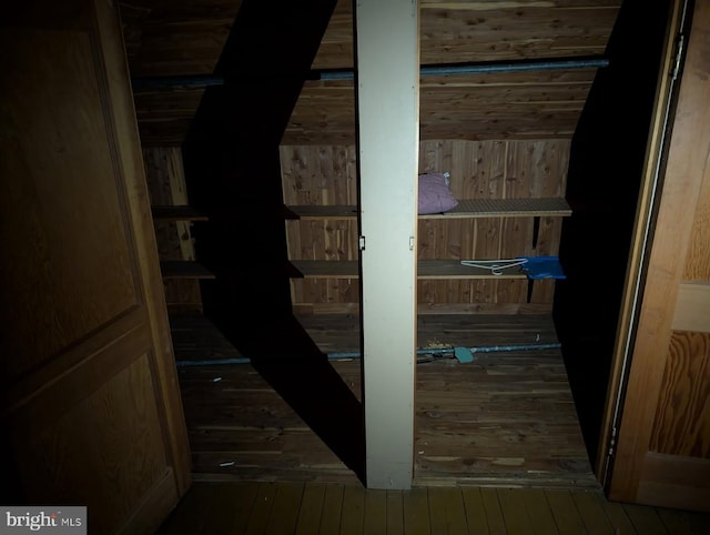 corridor featuring hardwood / wood-style floors and wood walls