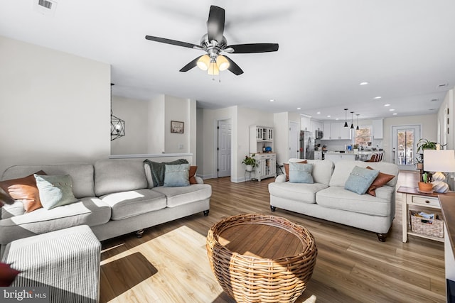 living area featuring visible vents, light wood finished floors, recessed lighting, and a ceiling fan