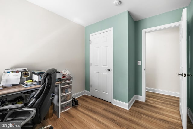 home office with baseboards and wood finished floors