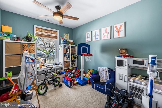 rec room with visible vents, ceiling fan, and carpet flooring