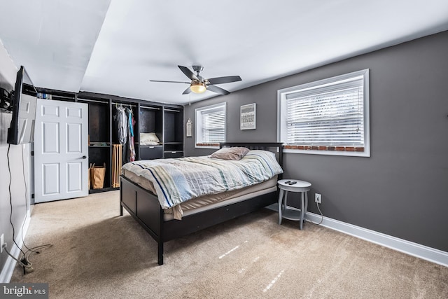 bedroom with carpet floors, baseboards, multiple windows, and a ceiling fan