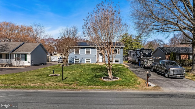 view of front of property featuring roof mounted solar panels, a front yard, and a residential view