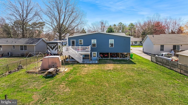 back of house featuring a yard, a wooden deck, fence, and stairway