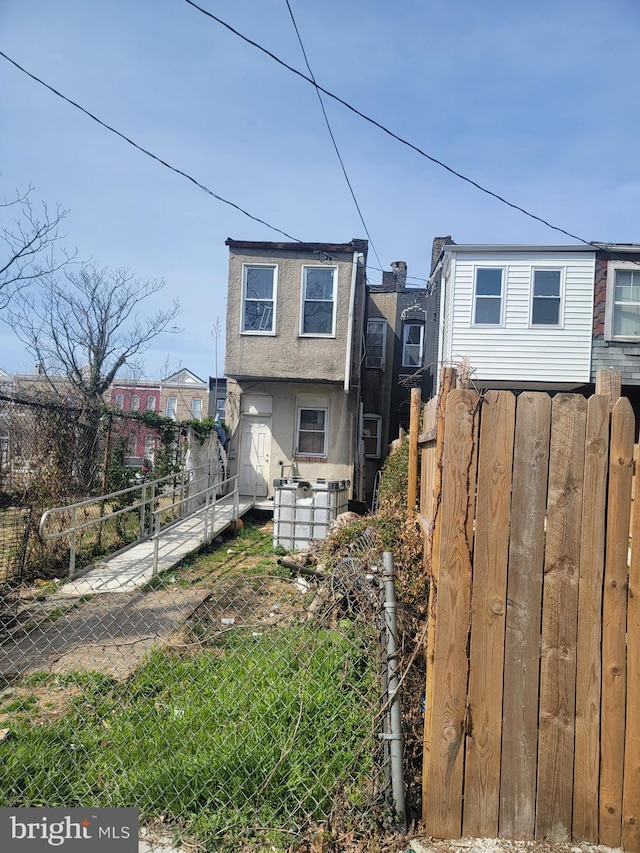 2419 Brentwood Ave, Baltimore, MD 21218 - view of front facade featuring stucco siding and fence