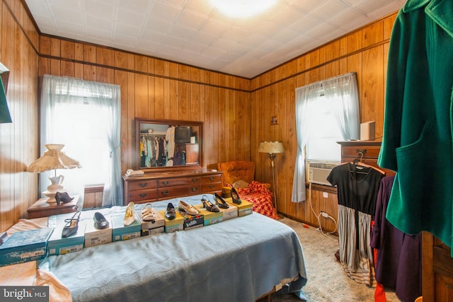 bedroom with cooling unit, wood walls, and carpet