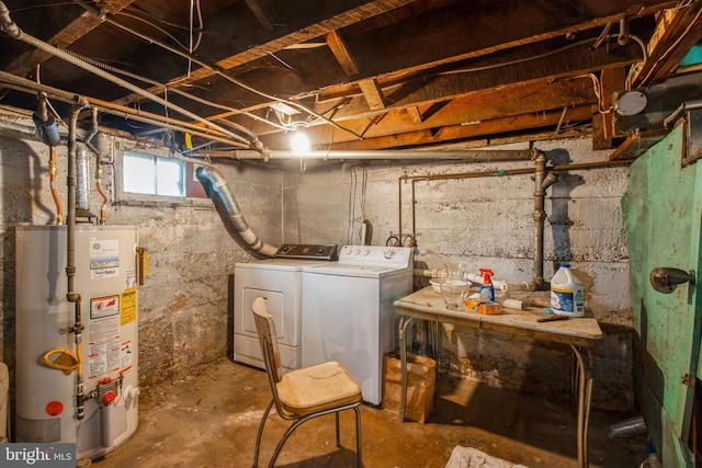 below grade area featuring water heater and washer and clothes dryer