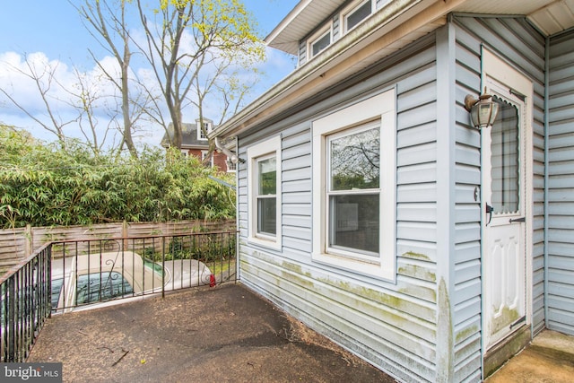view of side of home featuring fence and a patio area