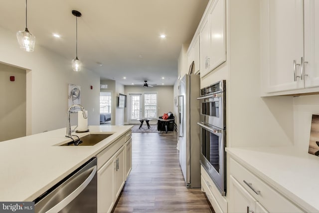 102 Saint Ives Unit 403, National Harbor, MD 20745 - kitchen with light countertops, appliances with stainless steel finishes, white cabinetry, a sink, and decorative light fixtures
