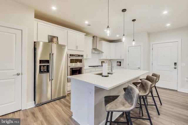 102 Saint Ives Unit 403, National Harbor, MD 20745 - kitchen featuring white cabinetry, a sink, appliances with stainless steel finishes, and wall chimney exhaust hood