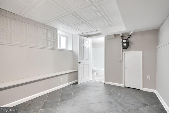below grade area featuring tile patterned flooring, baseboards, gas meter, and an ornate ceiling