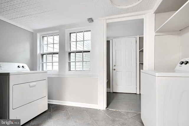 laundry area featuring washer and clothes dryer, baseboards, and tile patterned flooring