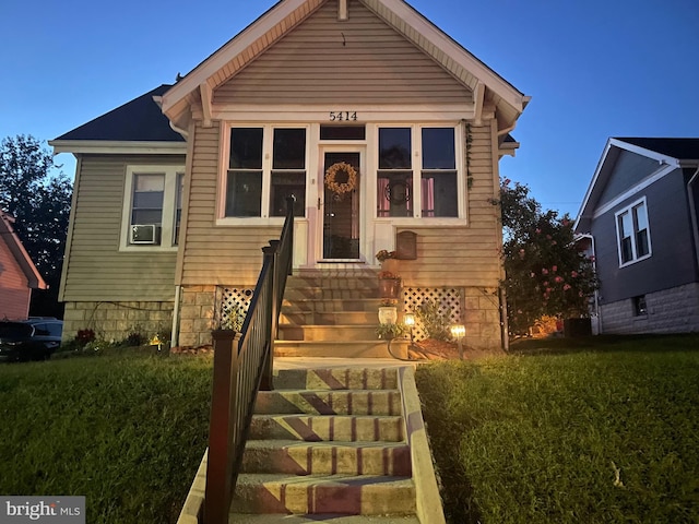 bungalow with a front lawn and entry steps