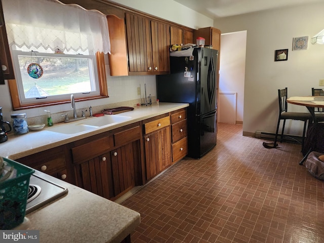 12114 Vale Smt, Frostburg, MD 21532 - kitchen with baseboards, freestanding refrigerator, a sink, light countertops, and brick patterned floor
