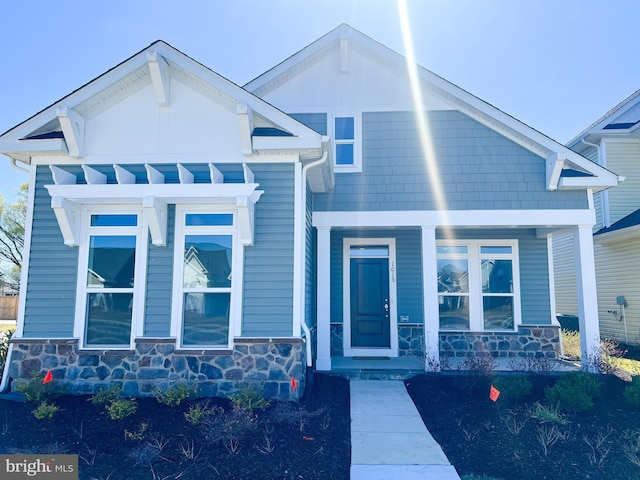 view of front of house with stone siding and a porch