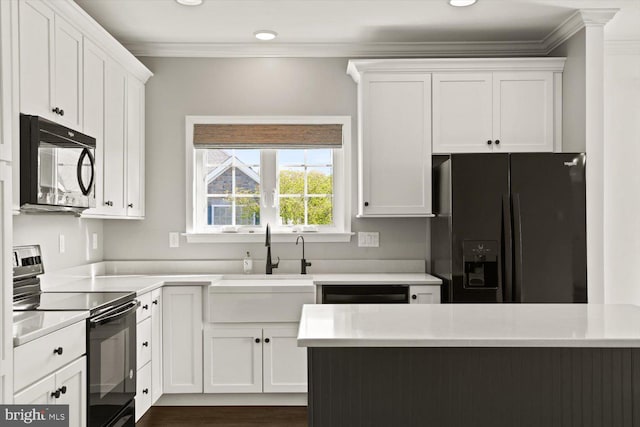 kitchen featuring crown molding, a sink, light countertops, white cabinetry, and black appliances