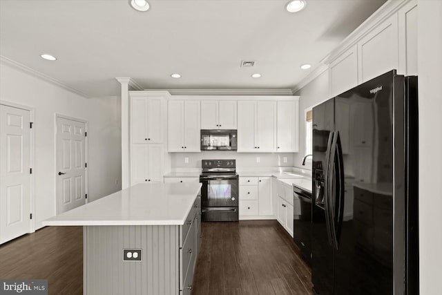 kitchen featuring ornamental molding, dark wood-style flooring, light countertops, a sink, and black appliances