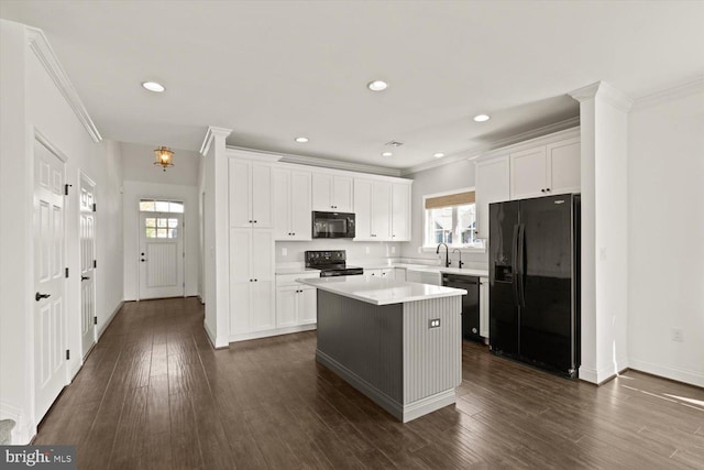 kitchen with a center island, crown molding, and black appliances