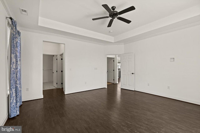 interior space with a raised ceiling, baseboards, dark wood-style floors, and visible vents