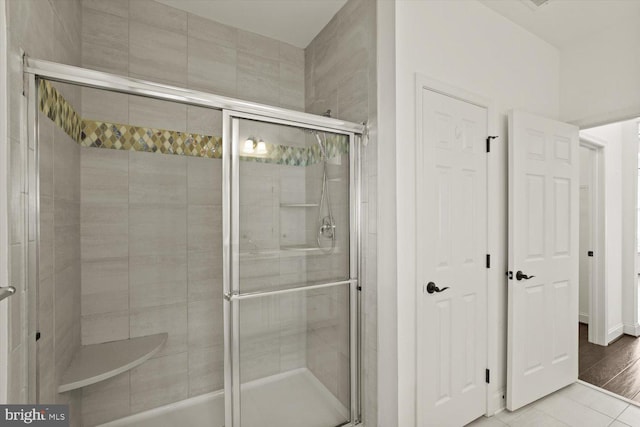 full bathroom with tile patterned flooring and a stall shower