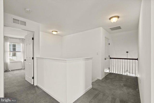 hallway with baseboards, carpet, and visible vents