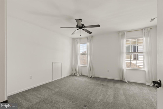 carpeted spare room with baseboards, a ceiling fan, and visible vents