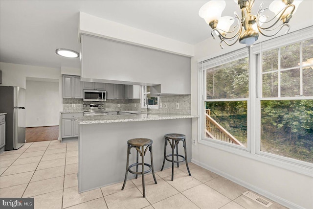 17 Alexandria Overlook Dr, Oxon Hill, MD 20745 - kitchen featuring visible vents, light tile patterned flooring, gray cabinets, stainless steel appliances, and a notable chandelier