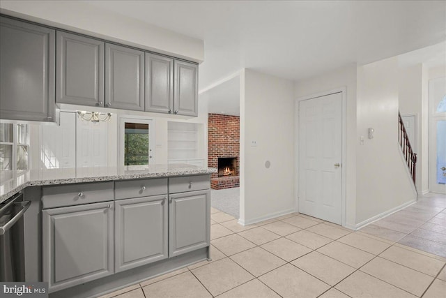 17 Alexandria Overlook Dr, Oxon Hill, MD 20745 - kitchen with light tile patterned flooring, a fireplace, gray cabinets, and light stone countertops