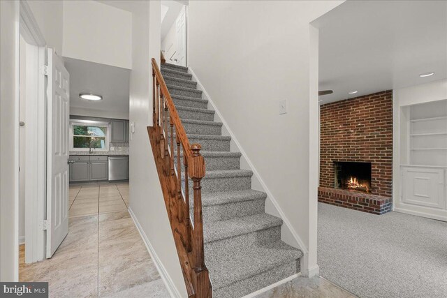 17 Alexandria Overlook Dr, Oxon Hill, MD 20745 - stairs with tile patterned flooring, built in shelves, carpet, baseboards, and a fireplace