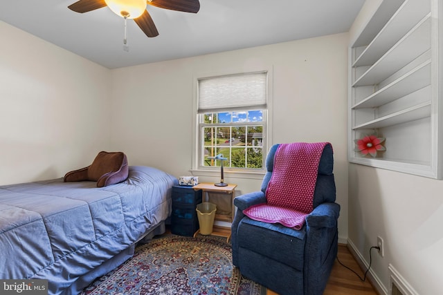 bedroom featuring baseboards, a ceiling fan, and wood finished floors