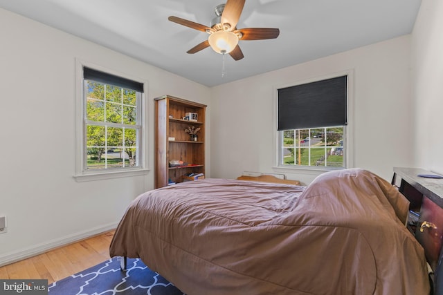 bedroom featuring baseboards, ceiling fan, and wood finished floors