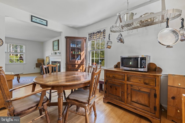 dining area featuring light wood-style floors and a fireplace
