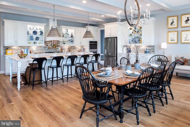 dining space with recessed lighting, a notable chandelier, beamed ceiling, and light wood-type flooring