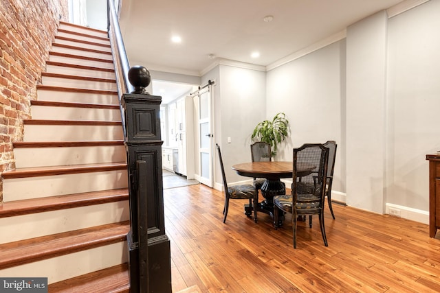 21 N Collington Ave N, Baltimore, MD 21231 - dining room with stairs, a barn door, light wood-style flooring, crown molding, and baseboards
