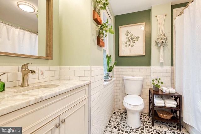 21 N Collington Ave N, Baltimore, MD 21231 - full bathroom with tile walls, vanity, tile patterned floors, toilet, and a wainscoted wall