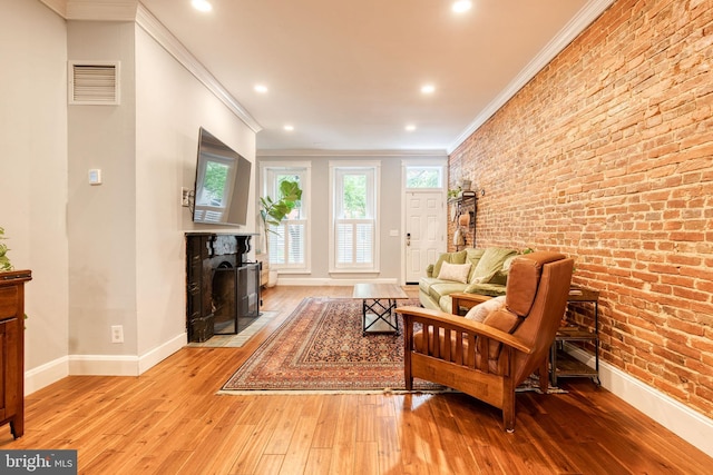 21 N Collington Ave N, Baltimore, MD 21231 - living room with ornamental molding, hardwood / wood-style floors, baseboards, a fireplace with flush hearth, and brick wall