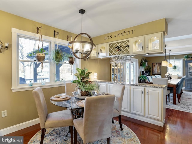 dining room featuring baseboards, dark wood-type flooring, and an inviting chandelier