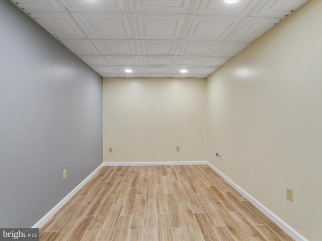 finished basement featuring light wood-style flooring, recessed lighting, and baseboards