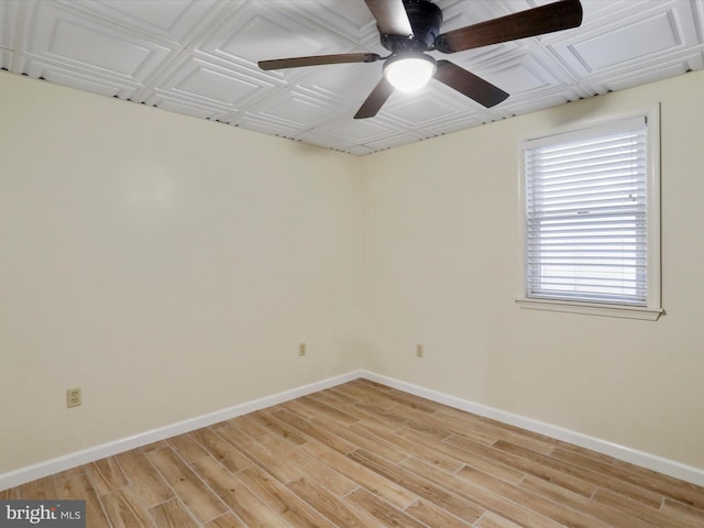 spare room featuring light wood-style flooring, baseboards, an ornate ceiling, and ceiling fan