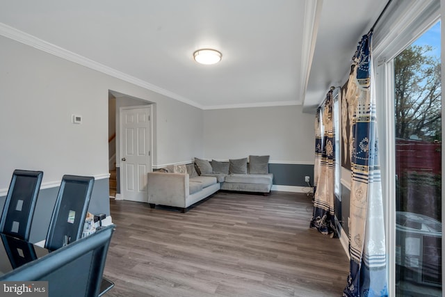 living area with stairway, wood finished floors, baseboards, and ornamental molding