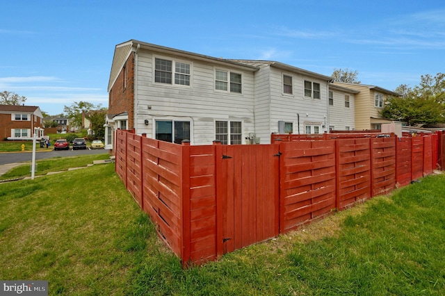 back of house featuring fence and a lawn
