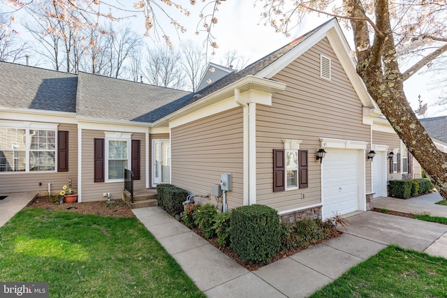 view of front of home featuring a front lawn, driveway, a garage, and roof with shingles