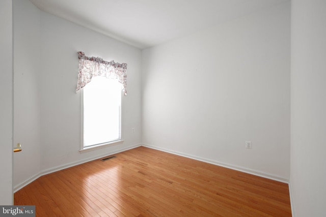 unfurnished room featuring light wood finished floors, baseboards, and visible vents