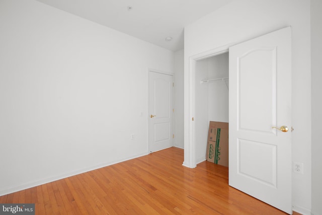 unfurnished bedroom featuring a closet and light wood-style floors