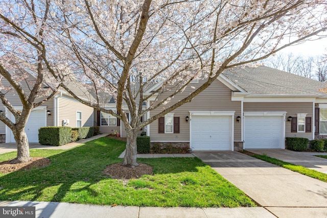 multi unit property featuring a front yard and concrete driveway
