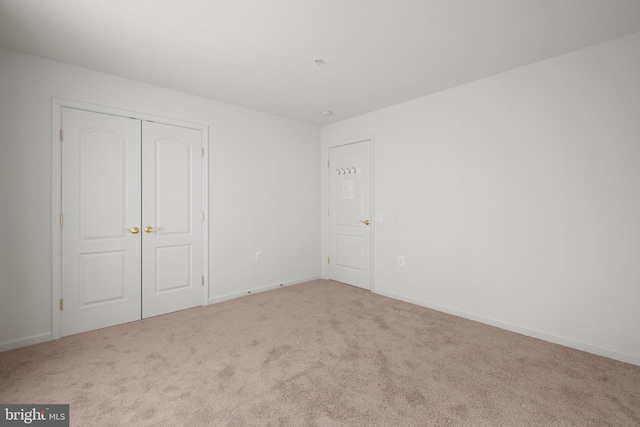 unfurnished bedroom featuring carpet flooring, a closet, and baseboards