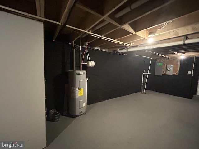 unfinished basement featuring electric panel and electric water heater