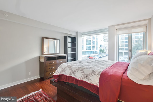 bedroom with access to outside, baseboards, dark wood-style floors, and multiple windows